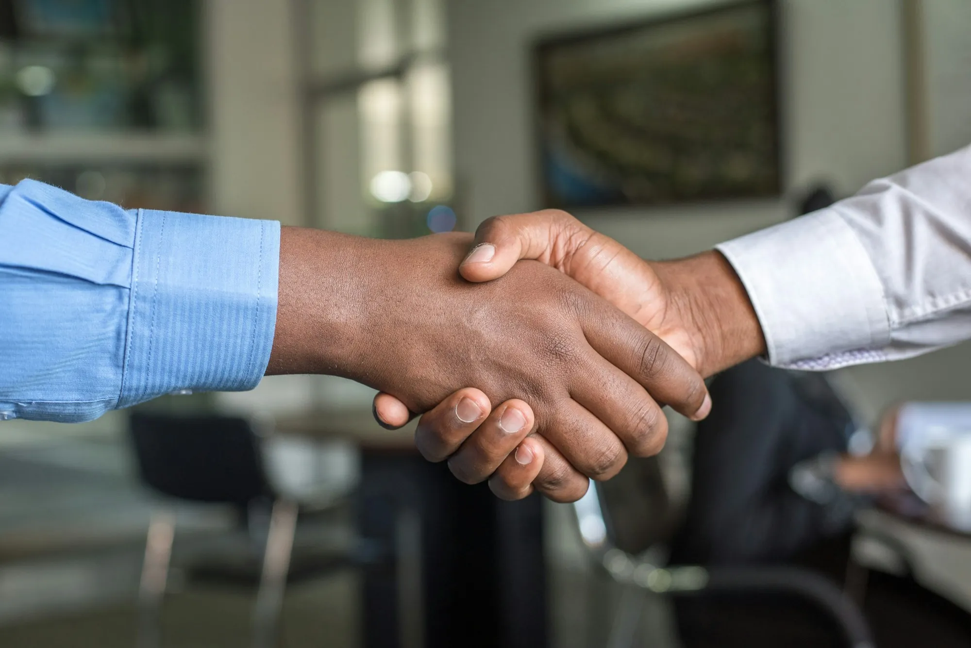 Two people shaking hands over a table