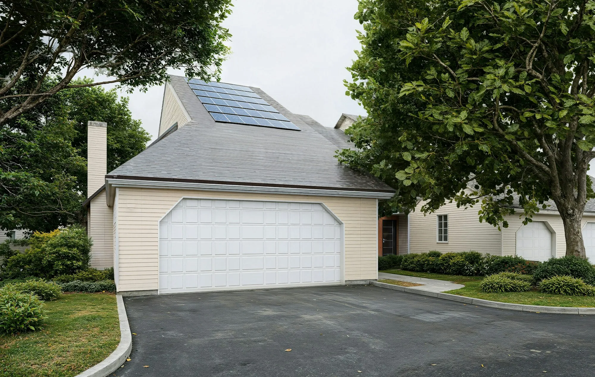 Solar panels on a gray shingle roof above a white two-car garage, the kind of Frankfort roof that has to handle snow load under an array